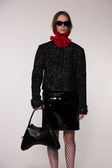 Model wearing the Helen Anthony red organza neck frill with detachable satin flower tie, styled with PU-coated high shine leather skirt and black leather small shoulder bag