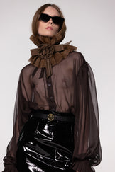 Model wearing the Helen Anthony black organza neck frill with detachable satin flower tie, styled with a sheer brown silk organza shirt 
